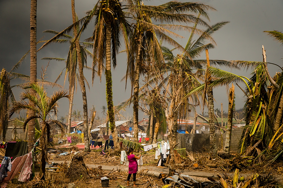 A woman hangs clothes on a line set against a backdrop of destruction near Tacloban City, Leyte province, Philippines on Tuesday, Nov. 19, 2013. The city and surrounding area were hit hardest by Typhoon Haiyan, leaving thousands dead and millions displaced. Photo by Erik M. Lunsford/LCMS