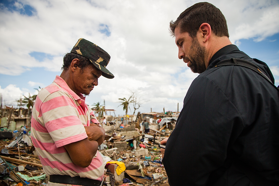 Rev. Ross Johnson, director of LCMS Disaster Response, prays with Tacloban resident John Lajara amongst the debris field in Tacloban City, Leyte province, Philippines on Tuesday, Nov. 19, 2013. Typhoon Haiyan caused widespread destruction, killing thousands and displacing millions of people. Photo by Erik M. Lunsford/LCMS