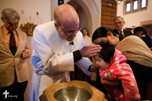 The Rev. Matthew Clark baptizes 21 Nepali immigrants, including Esther Gurung, on Sunday, Jan. 12, 2014, at Ascension Lutheran Church in St. Louis, Mo. LCMS Communications/Erik M. Lunsford