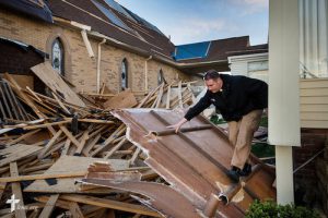 The Rev. Michael Meyer, manager of LCMS Disaster Response, climbs through debris Thursday, May 1, 2014, at Holy Trinity Lutheran Church in Tupelo, Miss. The church suffered catastrophic damage caused by a tornado earlier in the week. LCMS Communications/Erik M. Lunsford
