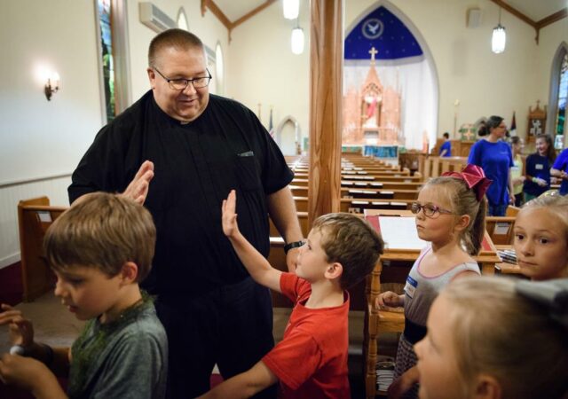 The Rev. David Daniel, pastor of Zion, high-fives campers at the end of the day. LCMS COMMUNICATIONS / ERIK LUNSFORD