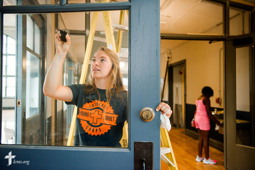 Megan Barz of Lutheran Young Adult Corps cleans windows as she serves with volunteers on Thursday, Aug. 10, 2017, at Eagle College Prep in south St. Louis. LCMS Communications/Erik M. Lunsford