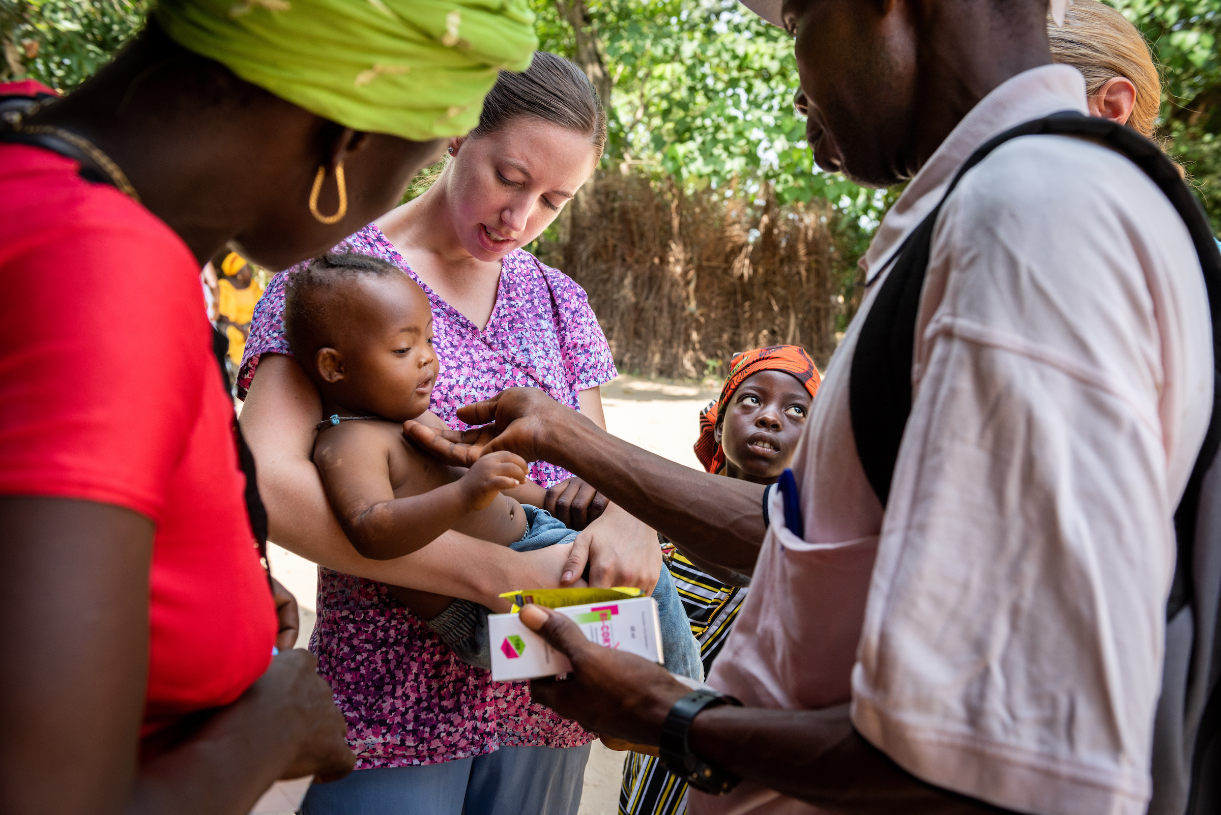Molly Christensen, career missionary to Togo, carries a baby suffering from a very high fever on the fifth day of the LCMS Mercy Medical Team on Friday, May 11, 2018, in the Yardu village outside Koidu, Sierra Leone, West Africa. LCMS Communications/Erik M. Lunsford