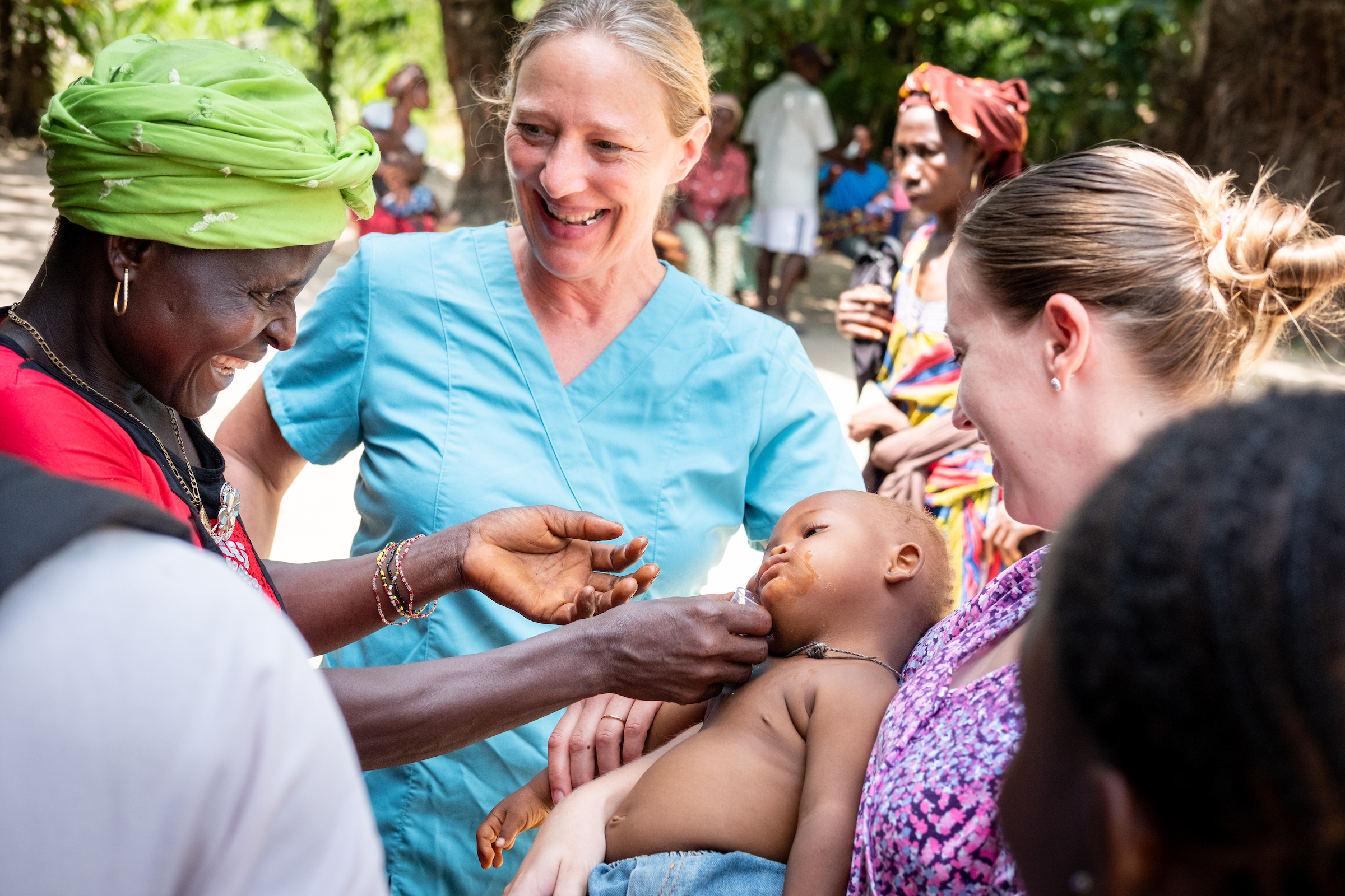 A mother gives medicine to her baby as LCMS missionaries Stephanie Schulte and Molly Christensen assist on the fifth day of the LCMS Mercy Medical Team on Friday, May 11, 2018, in the Yardu village outside Koidu, Sierra Leone, West Africa. LCMS Communications/Erik M. Lunsford