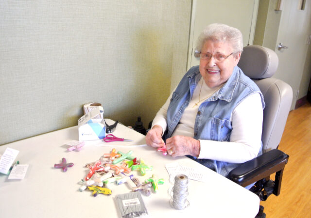 Perry Lutheran Home resident Virginia works on attaching tags with a Christian message to the prayer crosses. Used with permission / Perry Lutheran Home