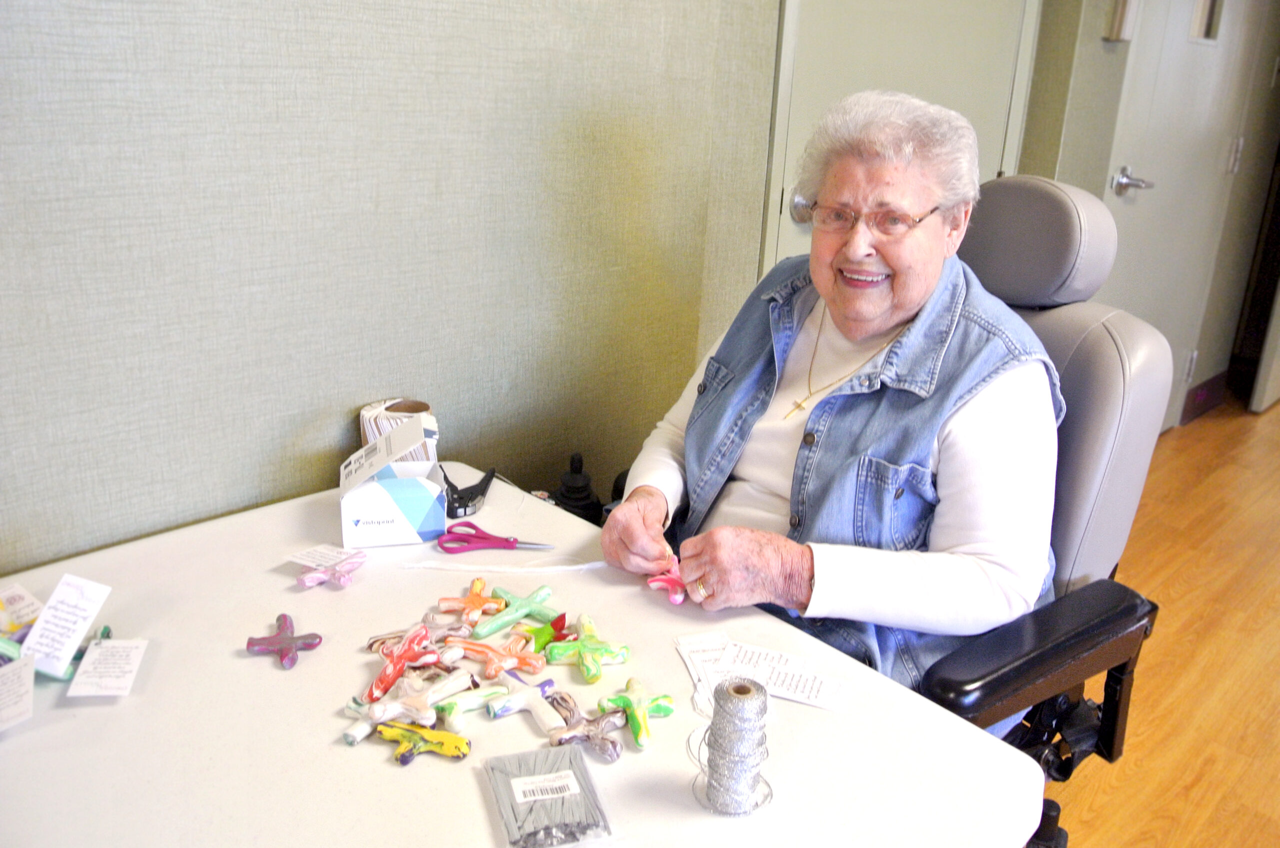 Perry Lutheran Home resident Virginia works on attaching tags with a Christian message to the prayer crosses. Used with permission / Perry Lutheran Home