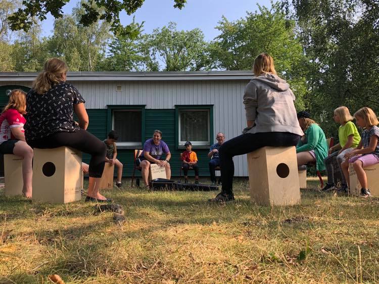 Summer Campers near Leipzig, Germany, play on new cajons (box drums) with Deaconess Kim Bueltmann. (Facebook: Deaconess in Deutschland)