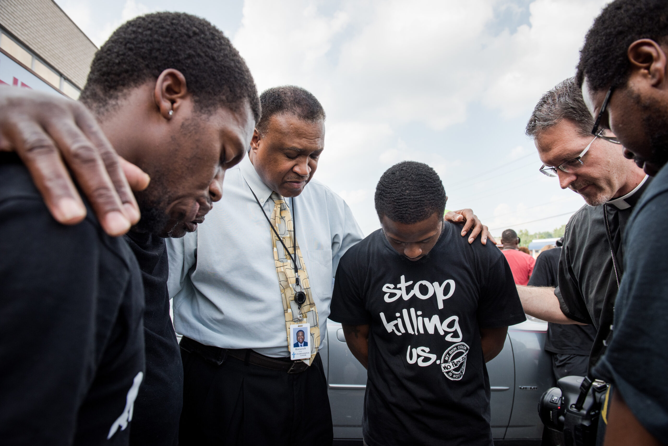 The Rev. Roosevelt Gray, director of LCMS Black Ministry (with tie), and the Rev. Steve Schave, director of LCMS Urban and Inner City Mission (second from right) pray with others along West Florissant Avenue on Monday, August 18, 2014, in Ferguson, Mo. LCMS Communications/Erik M. Lunsford